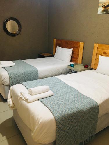 a hotel room with two beds with towels on them at Asante’s Guest House in Calcutta