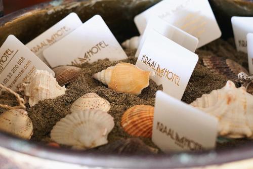 a bowl full of sand and shells with signs on it at Kraal Hotel Vlore in Vlorë