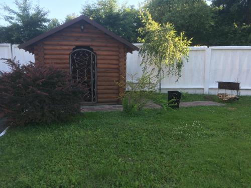 a small wooden dog house in a yard at mini-hotel Neptun in Rivne