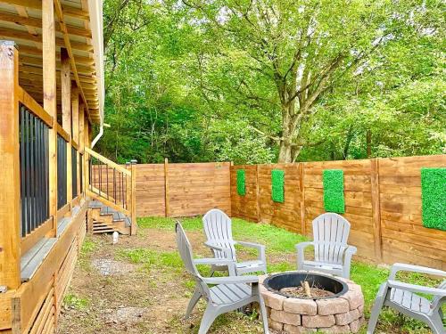 a patio with two white chairs and a fire pit at New Tiny cabin Hot tub Firepit Fenced yard in Sevierville
