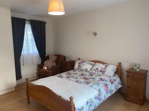 a bedroom with a bed with a teddy bear on it at Hillview Cottage in Bantry