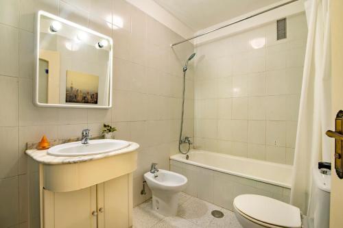 y baño con lavabo, aseo y bañera. en Alquilaencanarias- Medano Apartment Bogavante, en El Médano