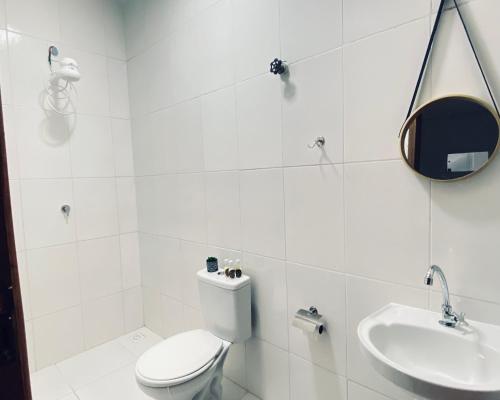 a white bathroom with a toilet and a sink at Pousada Boa Vista in Canindé de São Francisco