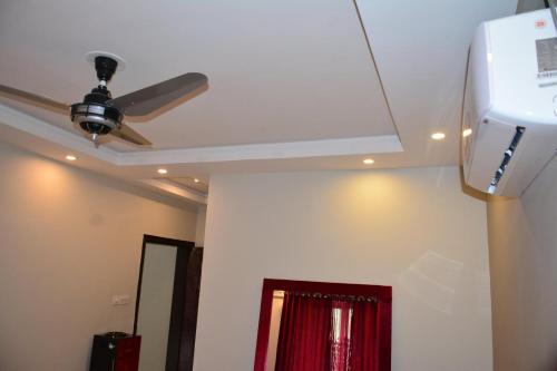 a ceiling fan in a room with a red curtain at Hotel La Orilla Muzaffarabad in Muzaffarabad