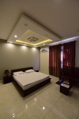 a bedroom with a large bed and a window at Hotel La Orilla Muzaffarabad in Muzaffarabad