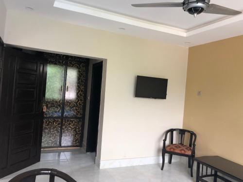 a room with a black door and a tv on a wall at Hotel La Orilla Muzaffarabad in Muzaffarabad