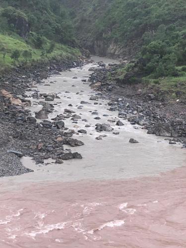 a river with rocks on the side of a mountain at Hotel La Orilla Muzaffarabad in Muzaffarabad