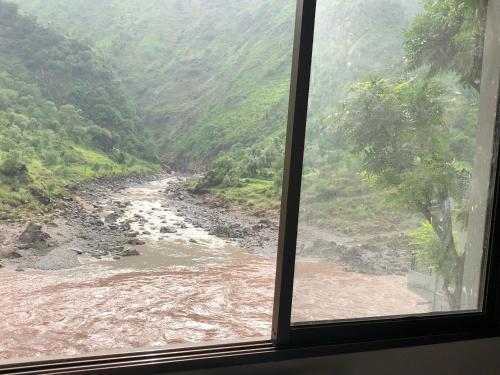 a view of a river from a window at Hotel La Orilla Muzaffarabad in Muzaffarabad