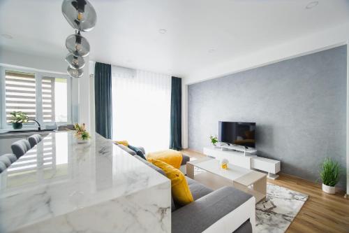 a living room with a glass table and a couch at Elegant & Spacious – Central Apartment in Oradea