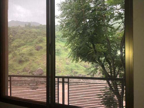 a window with a view of a green field at Hotel La Orilla Muzaffarabad in Muzaffarabad