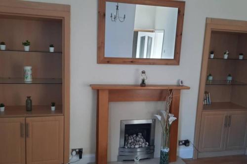 a living room with a fireplace and a mirror at Sunderland short stay 2-bed retreat apartment in Fulwell in Monkwearmouth