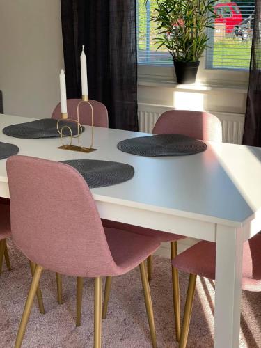 a white table with pink chairs around it at Torggatan 54 in Mariehamn