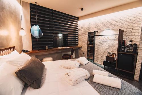 a bedroom with a white bed with towels on it at Project 3 Urban Chic Hotel in Athens