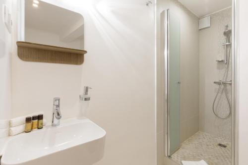 une salle de bain blanche avec un lavabo et une douche dans l'établissement Great Sea View YourHostHelper, à Cannes