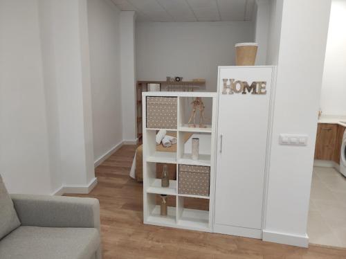 a living room with a white cabinet with shelves at APARTAMENTO TURISTICO LEO BAENA in Baena