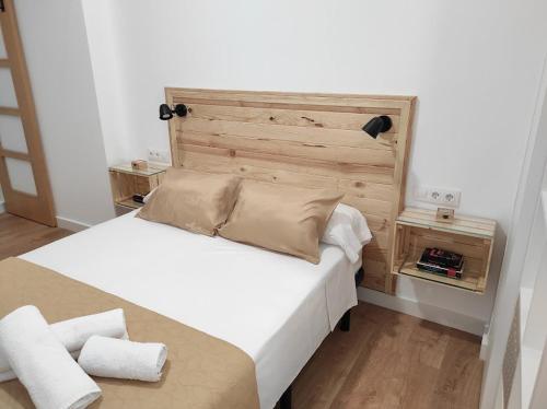 a bedroom with a large bed with a wooden headboard at APARTAMENTO TURISTICO LEO BAENA in Baena