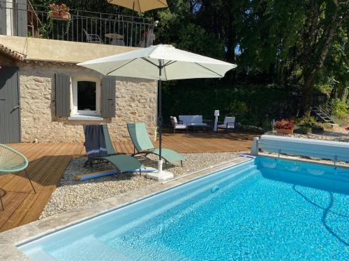 una piscina con sombrilla, sillas, mesa y sombrilla en Chambres d'Hôtes La Bastide St Julien en Anduze