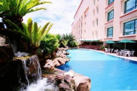 a swimming pool in front of a building at Grand Palace Hotel in Miri