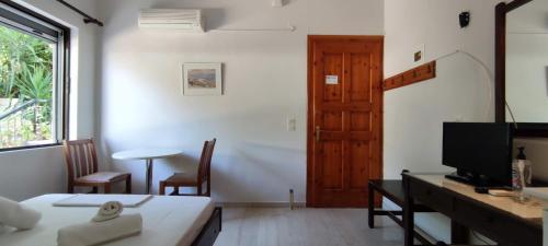 Habitación con cama y escritorio con TV. en Anna Studio and Apartments, en Tsilivi