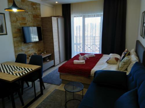 Una habitación de hotel con una cama, una mesa y sillas. en Okili apartman S11 Milmari resort Kopaonik, en Kopaonik