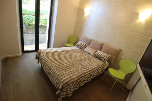 - une chambre avec un lit et deux chaises vertes dans l'établissement SUPERBE MAISON DE VILLE, à Cannes
