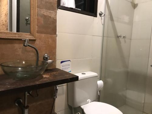 uma casa de banho com um lavatório e um WC em Praia Comprida Flats em Abraão