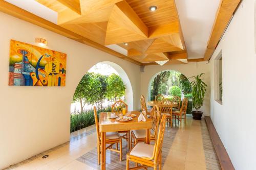 a dining room with a table and chairs and a painting on the wall at Hotel Hacienda Montesinos in Morelia