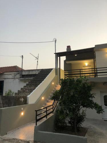 a building with a stair case and a building with a tree at Fontana Leone in Spílion