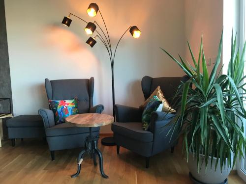 a living room with two chairs and a table and a plant at Ferienwohnung Schönblick in Sommerhausen
