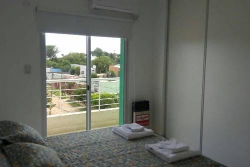 1 dormitorio con cama y ventana grande en Alojamientos Litoral - 3A en Gualeguaychú