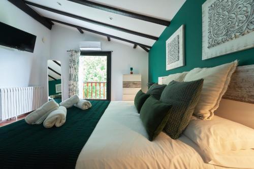 ein Schlafzimmer mit einem großen Bett mit grünen Wänden in der Unterkunft Villa Higer in Hondarribia