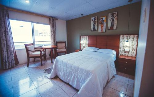 a bedroom with a bed and a table and chairs at Golden Hotel in Quevedo