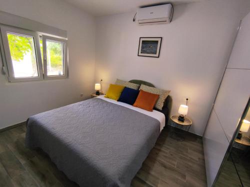 1 dormitorio con 1 cama con almohadas coloridas en Celtis Shade House en Virpazar