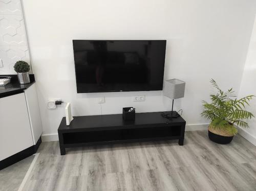 a living room with a flat screen tv on a wall at APARTAMENTO TURISTICO LYRA BAENA in Baena