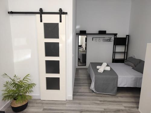 a bedroom with a bed and a table and a mirror at APARTAMENTO TURISTICO LYRA BAENA in Baena
