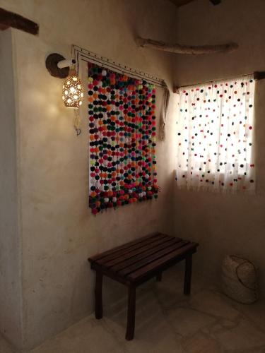 a bench in a room with a painting on the wall at Talist Siwa in Siwa