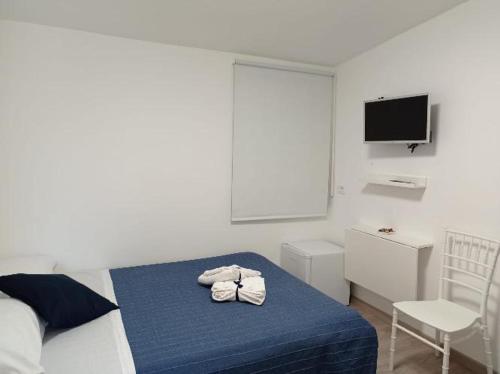 a bedroom with a bed with blue sheets and a chair at Bouganville da Giò in Scalea