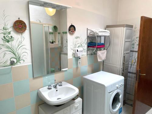 a bathroom with a sink and a washing machine at La Torre in Sinalunga