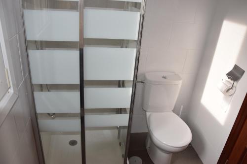 een badkamer met een toilet en een glazen douche bij Viv Tur LA QUINTANA II in Arredondo