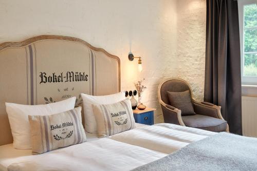 a bedroom with a bed with white sheets and pillows at Bokel-Mühle am See in Bokel