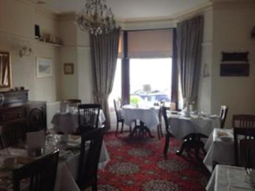 una sala da pranzo con tavoli, sedie e una finestra di Yacht Bay View a Morecambe