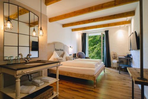 a bedroom with a bed and a sink and a mirror at Bokel-Mühle am See in Bokel