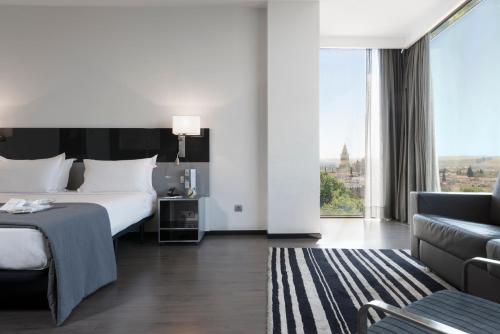 a hotel room with a bed, chair, and nightstand at Eurostars Palace in Córdoba