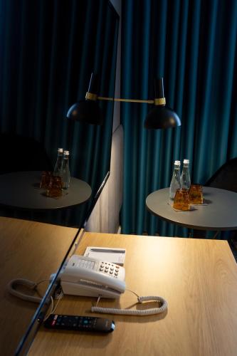 a table with a phone and a remote control on it at Hotel & SPA Hetman in Siedlce