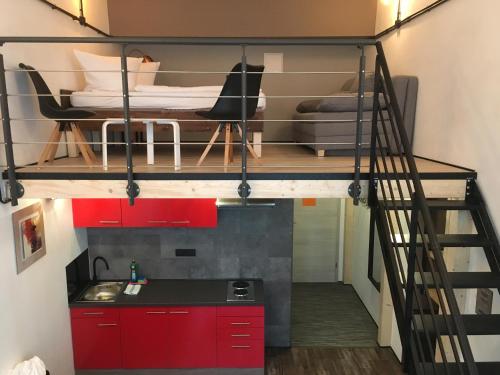 a loft bed in a room with a kitchen at Cityflair Berlin Apartments & Rooms in Berlin
