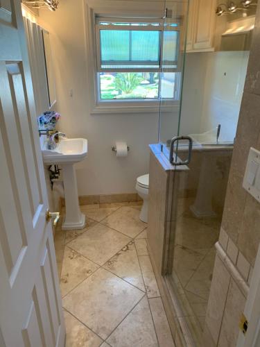 baño con lavabo y aseo y ventana en Rustling Leaves 2bd/1 ba Upstairs Parking/Laundry, en Los Ángeles
