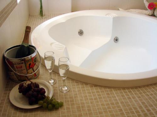 a bath tub with glasses of wine and a plate of grapes at Hotel Melodia in Lima