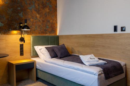 a bedroom with a bed and a table with a lamp at Hotel & SPA Hetman in Siedlce