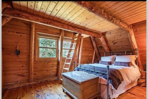 een slaapkamer met een bed in een blokhut bij The Beaver Lodge by Escapades Tremblant in Lac-Superieur