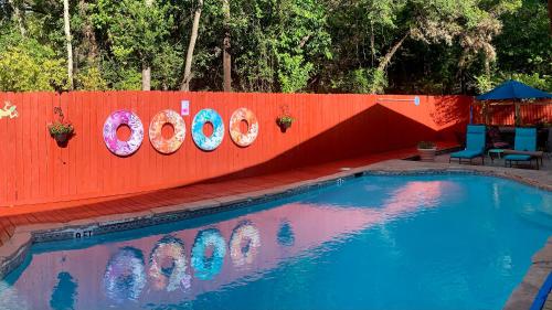 a swimming pool next to a red fence at Lamb's Rest Inn in New Braunfels